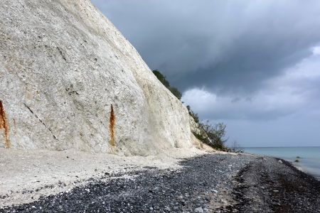 Když slunce vysvitlo, sněhově bílé útesy neskutečně zářily před temnými mraky.