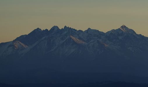 Na Lomnickém štítu se od něčeho odráží světlo zapadajícího slunce.