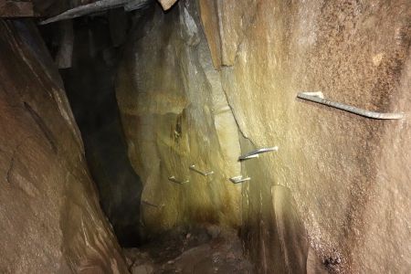 Slézáme po žebřících do jeskyně.