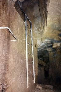 Slézáme po žebřících do jeskyně.