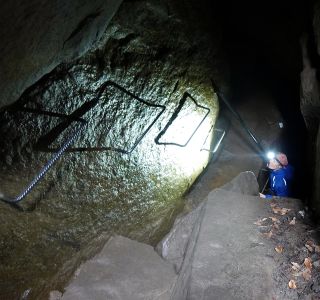 Slézáme po žebřících do jeskyně.