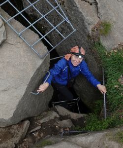 Slézáme po žebřících do jeskyně.