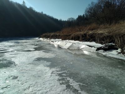 Ledové kry u břehu v paprscích světla.